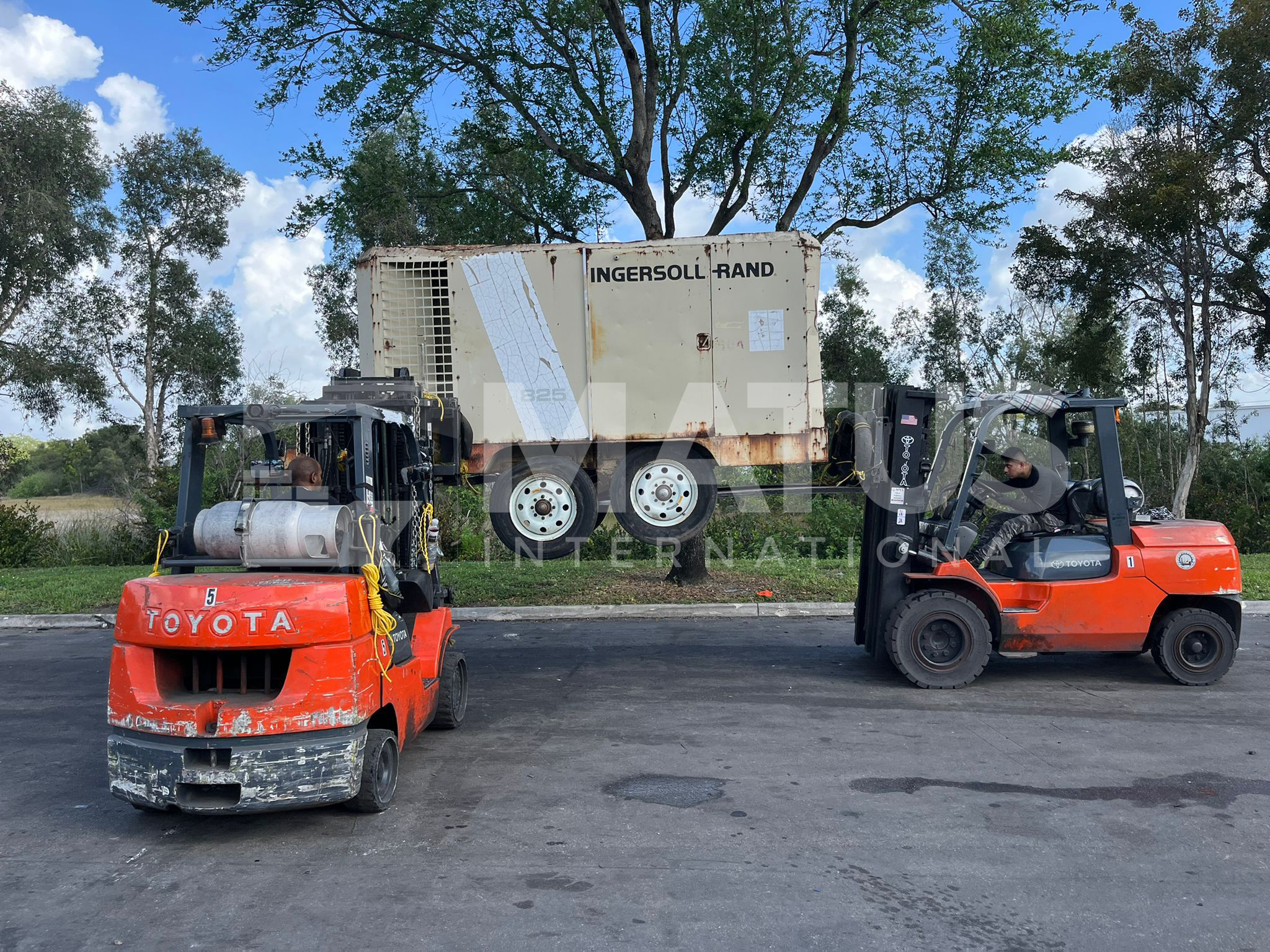 Envío de vehículos con equipo pesado siendo manipulado por montacargas durante el proceso de carga